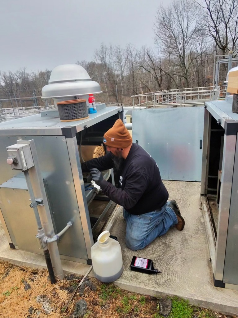 Technician performing hands-on blower maintenance