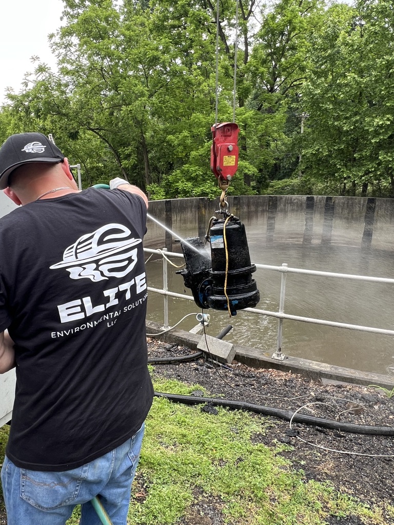 Elite team member cleaning a suspended pump at a wastewater facility